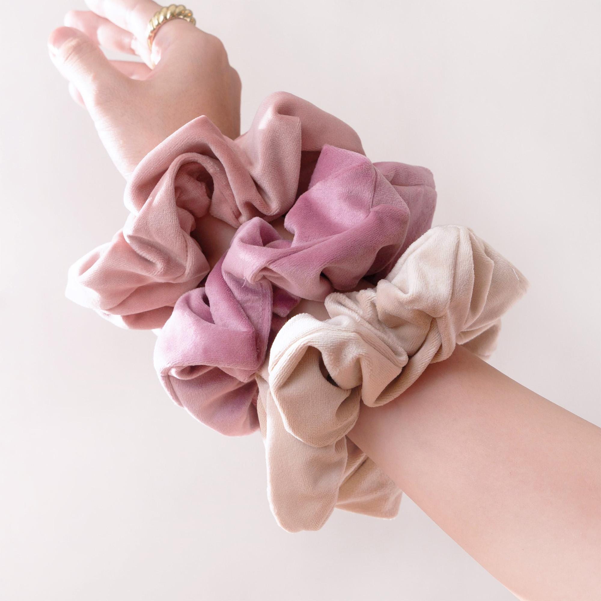 a woman's arm with a pink scrunffle on it