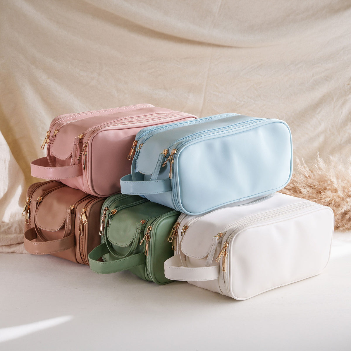 Stack of side handle cosmetic bags in blue, white, green and khaki
