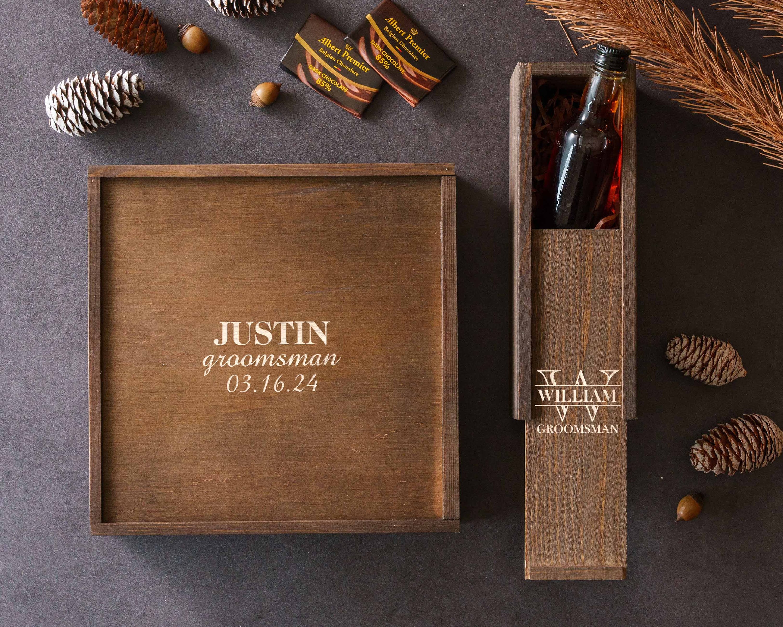 a bottle of wine in a wooden box next to some pine cones