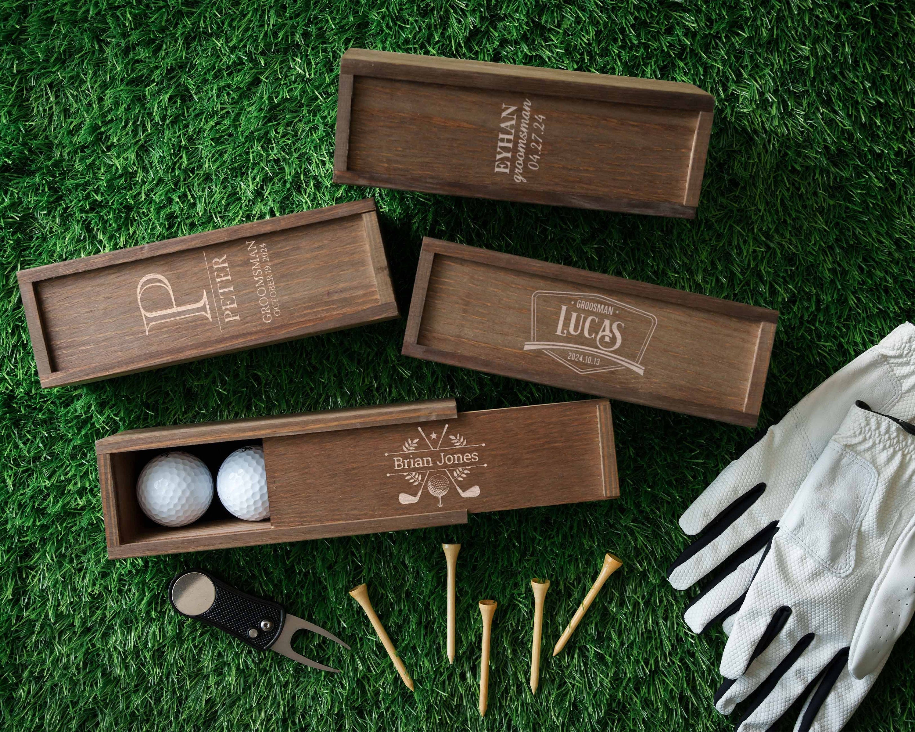 a box of golf balls, gloves, and tees on the grass