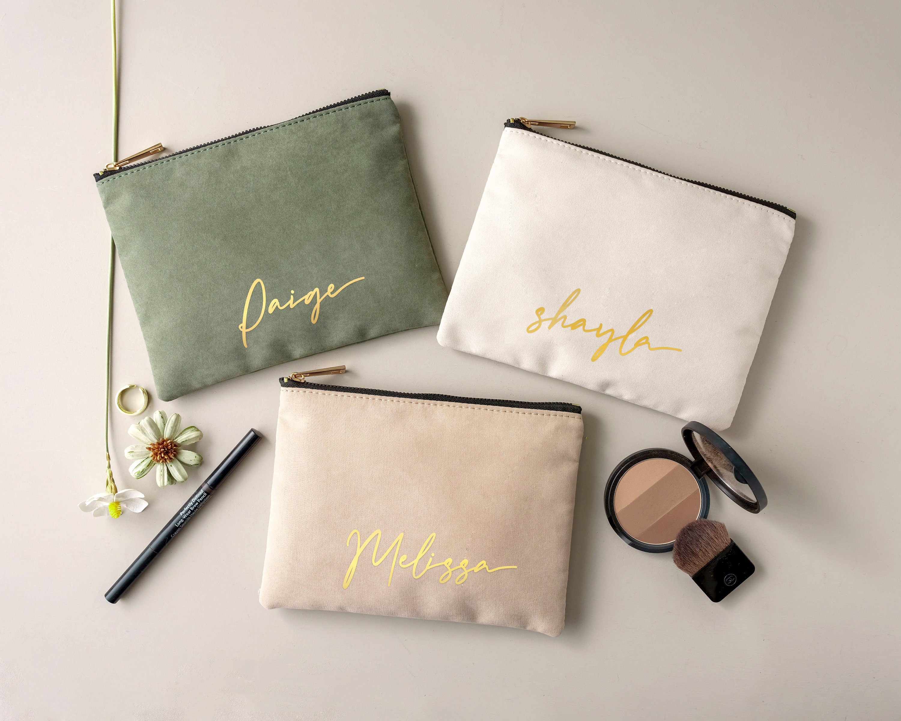 three personalized makeup bags and a brush