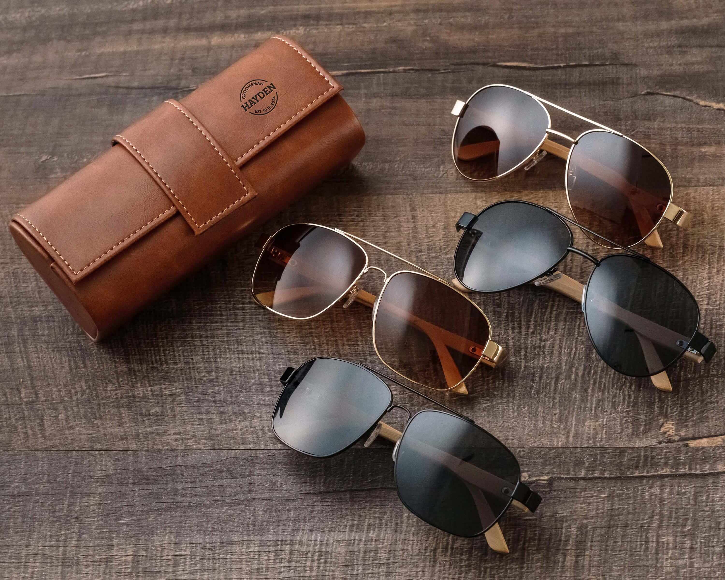 three pairs of sunglasses sitting on a wooden table