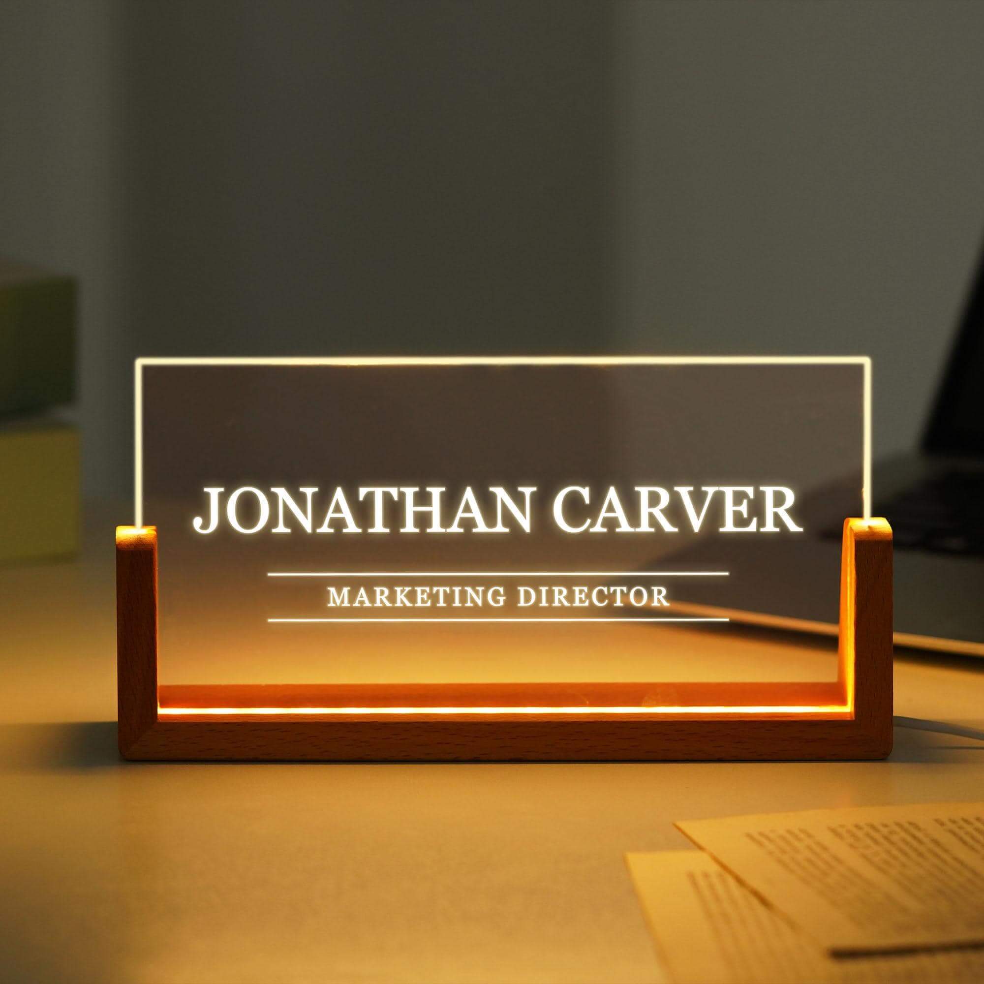a lighted business name plate sitting on a desk