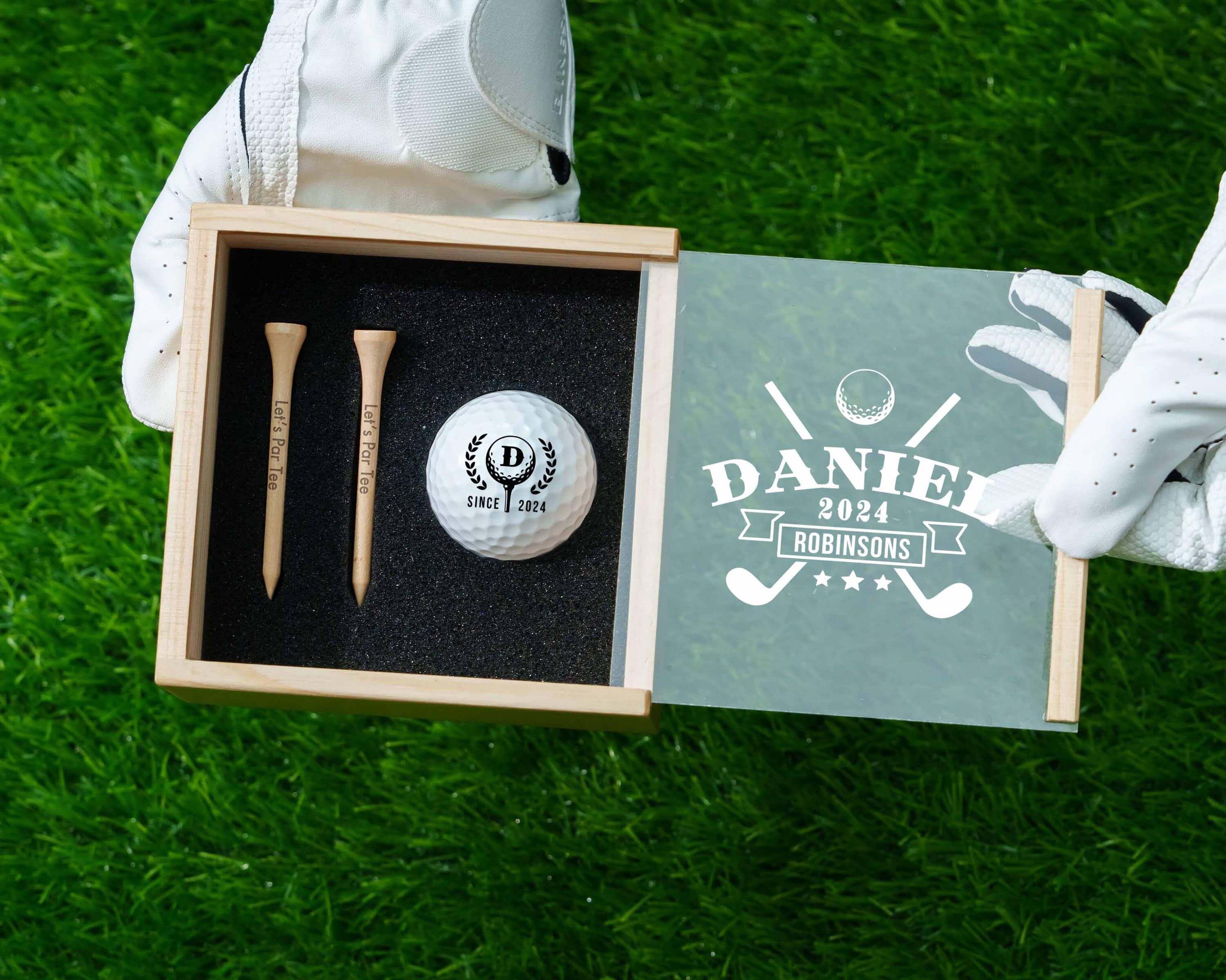 a pair of golf gloves and a golf ball in a box