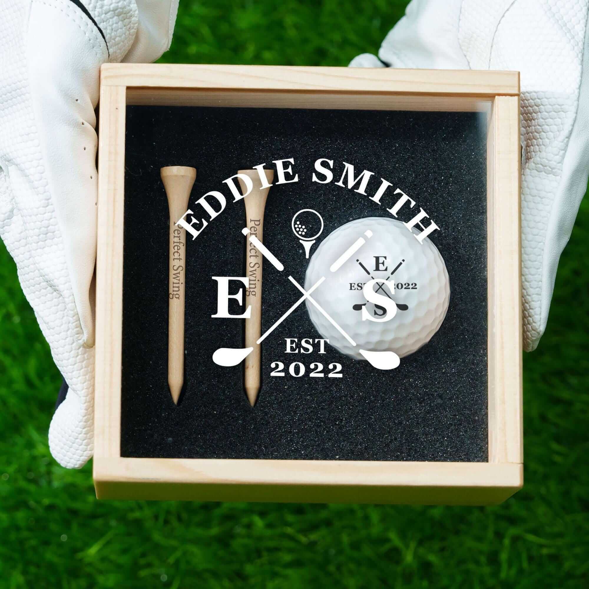 a person holding a box with a golf ball and tee in it