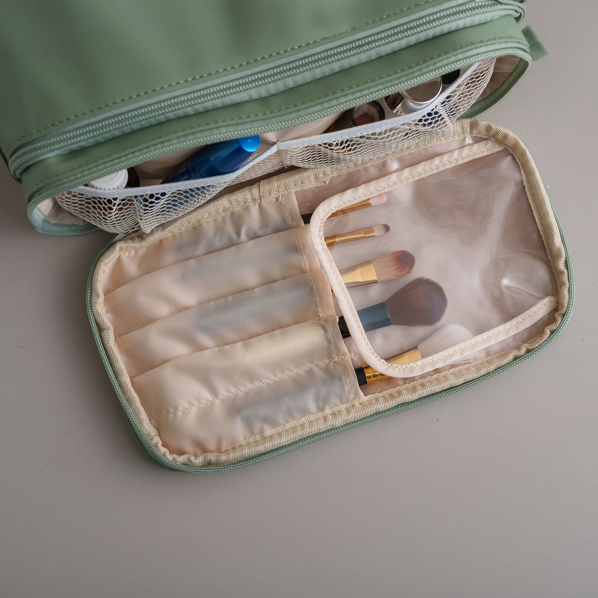 Inside of the cosmetic bag with a clear zip pocket and brush holders