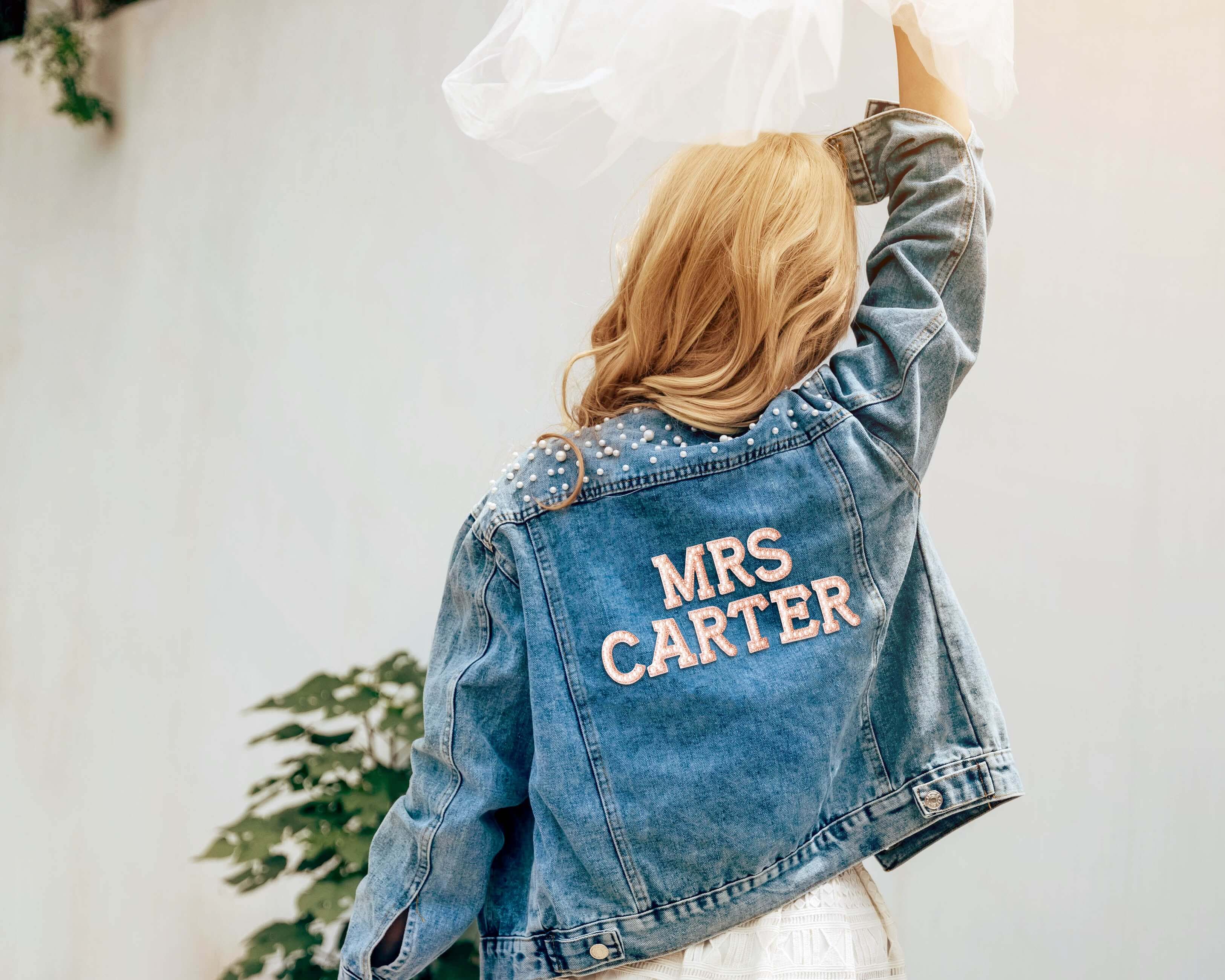 A beautiful bride wore a custom bride jean jacket with pearls on her wedding day.