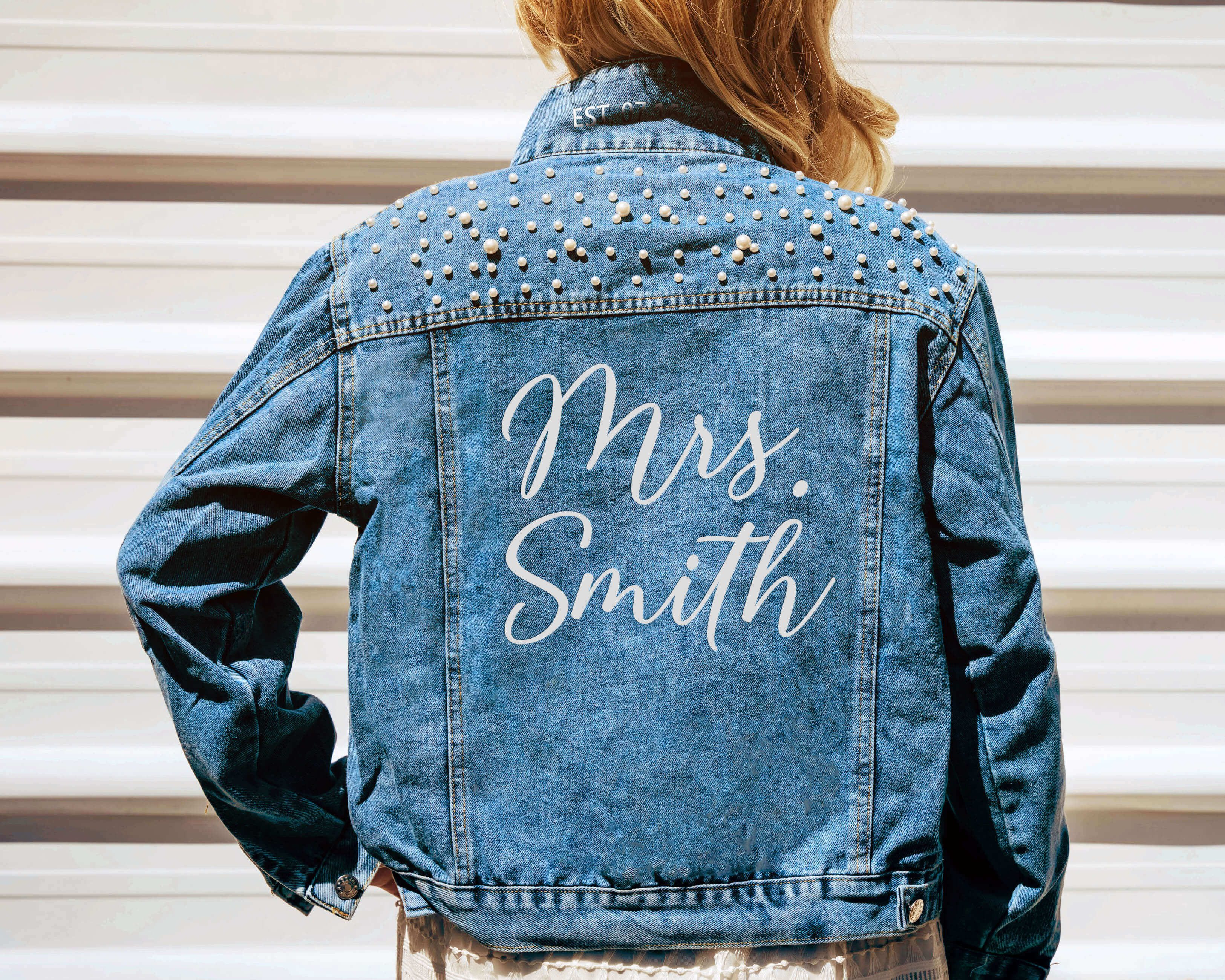 A beautiful bride wear a custom bride jean jacket with custom text on her wedding day.